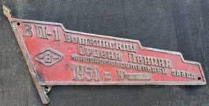 Fabrikschild Votkinsk, Fabriknummer: 899, Baujahr: 1951. Aluminiumguss, Sonderform, glatt mit Rand. Diagonale = 460 mm. Die Maschinenfabrik Votkinsk baute bis 1917 Lokomotiven, dann bis zum Ende des WWII Waffen. Zwischen 1947 und 1960 wurden etwa 2350 Schmalspurlokomotiven der Serie VP -1-4 gebaut. Das ist auf dem Schild vermerkt. Heute ist das Werk einer der wichtigsten R�stungsbetriebe und baut Raketen f�r Atomsprengk�pfe und die gef�rchtete Iskander-Rakete.